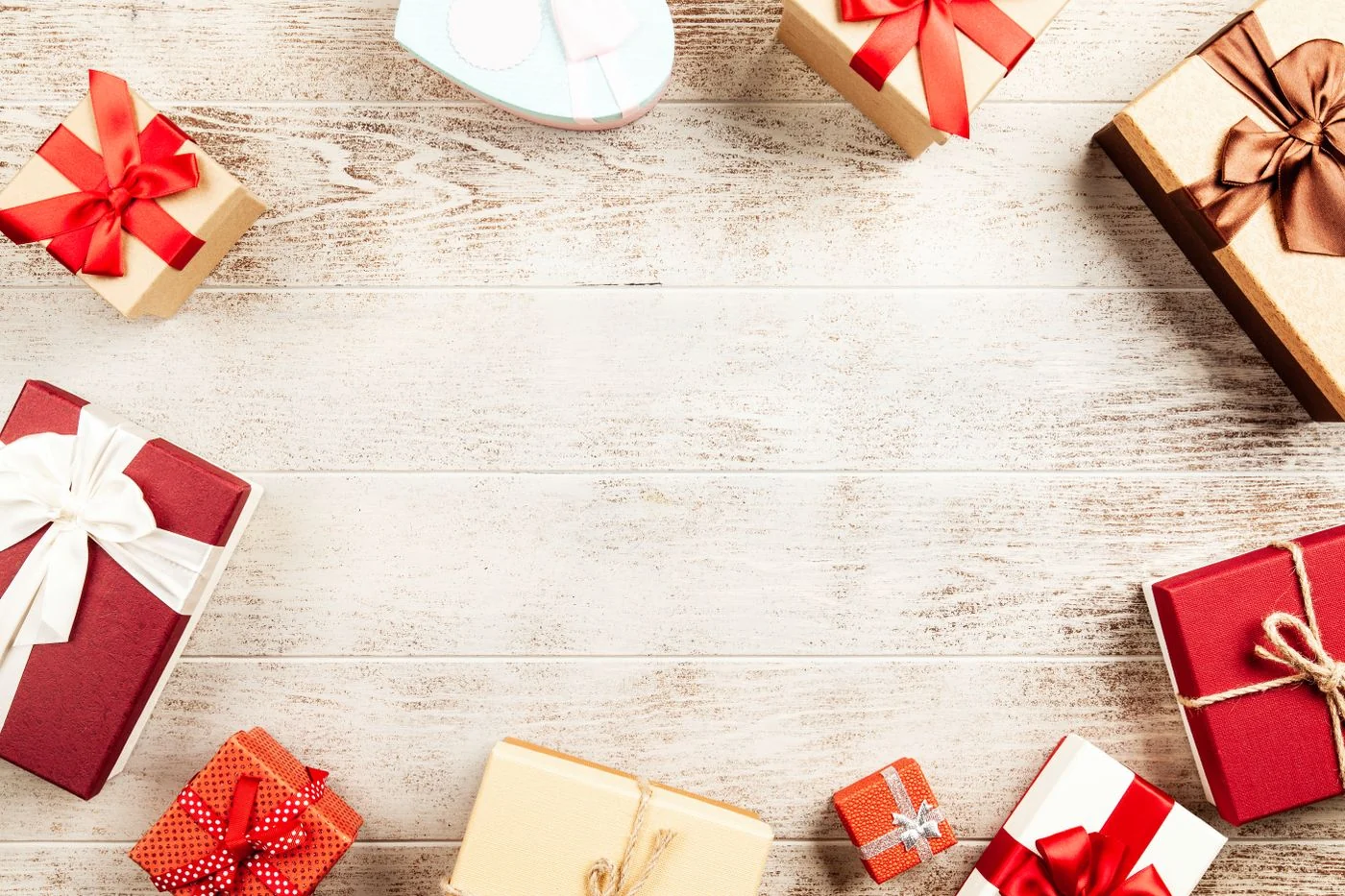 A collection of beautifully wrapped gift boxes with ribbons on a wooden table, perfect for holiday themes.