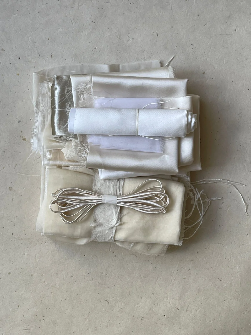 Folded neutral fabric samples tied with a length of cord.