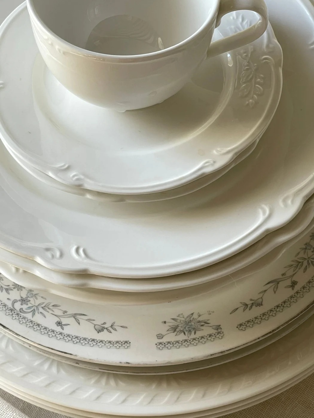 White porcelain cups and plates with scalloped rims.