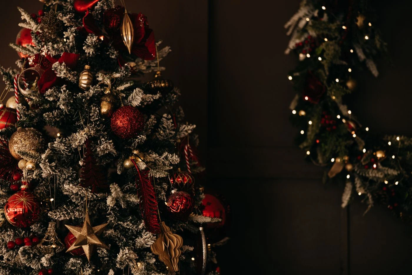 A beautifully decorated Christmas tree with red and gold ornaments under warm lighting indoors.