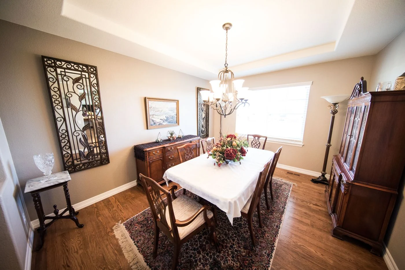 Beautifully designed dining room featuring traditional wooden furniture and a decorative chandelier.