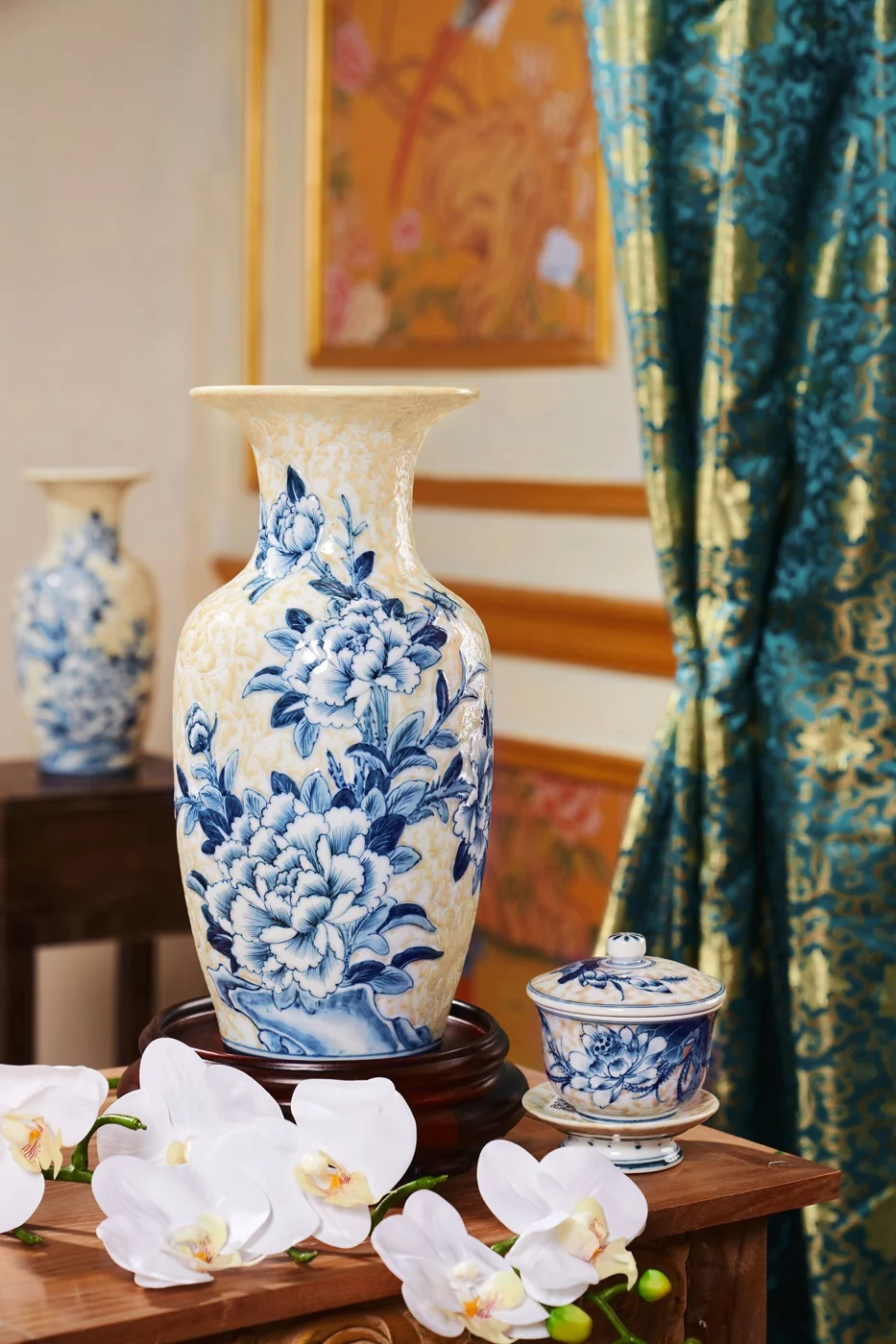 Stylish blue and white porcelain vase with floral motifs in an interior setting.