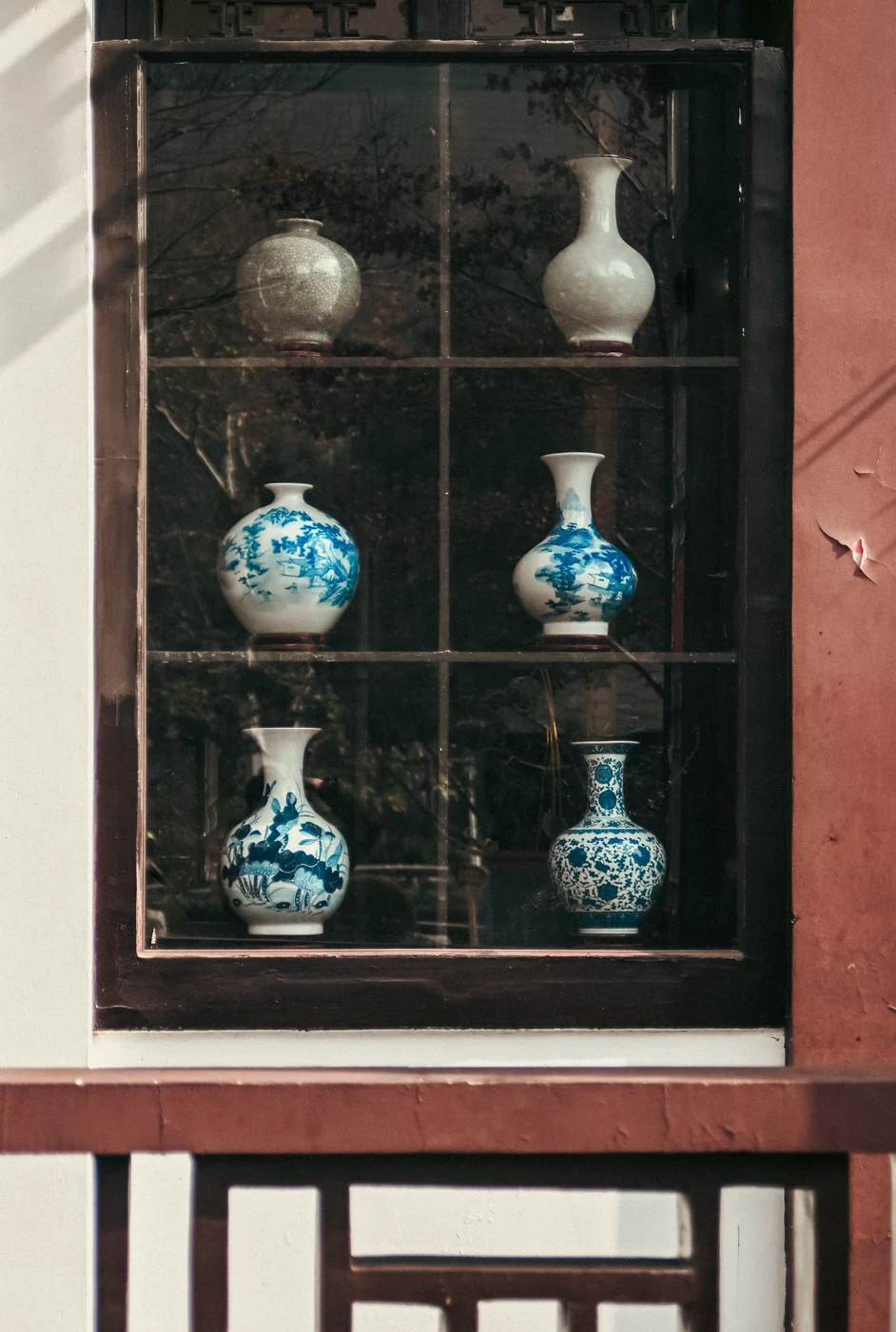 A collection of blue and white porcelain vases displayed in a window in Nanjing, China.