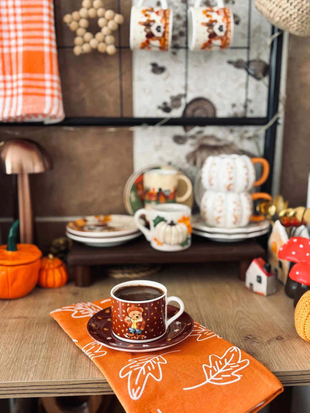 Warm autumn interior with coffee cup and pumpkin decor, perfect for cozy fall vibes.