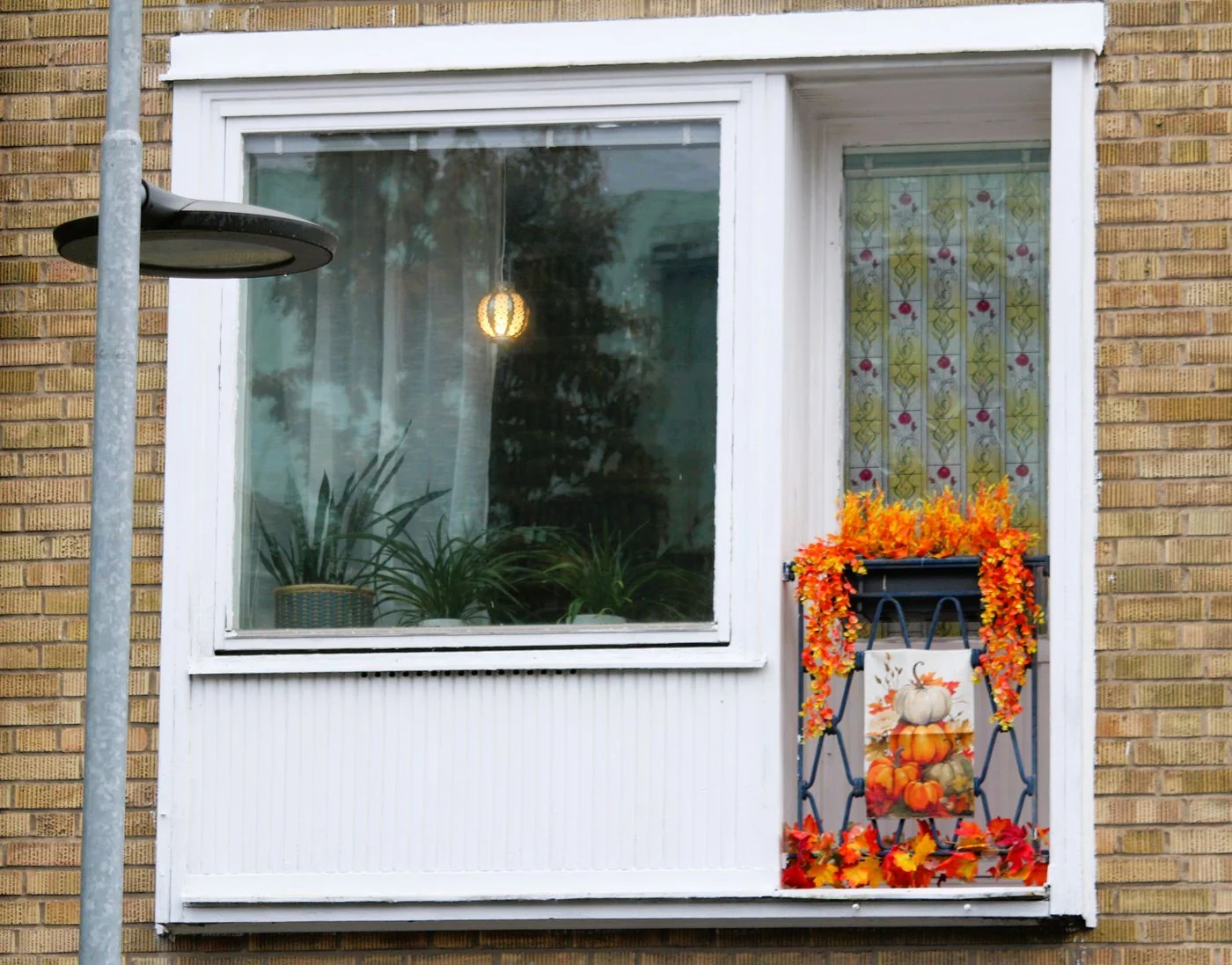 Cozy autumn-themed balcony with pumpkins and orange leaf decor.