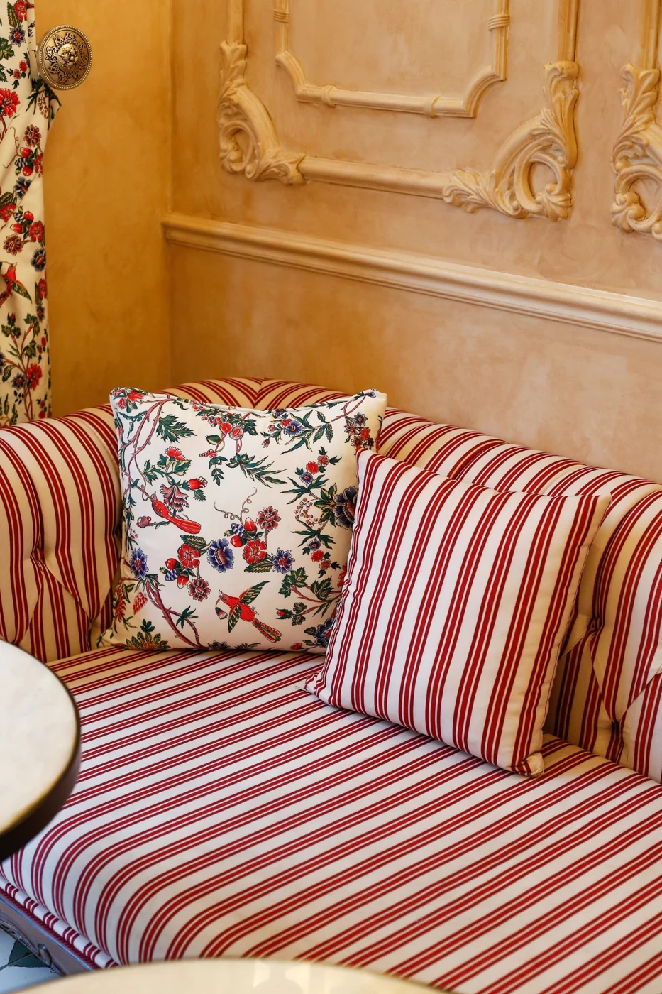 Cozy living room corner with striped sofa and floral pattern cushions.