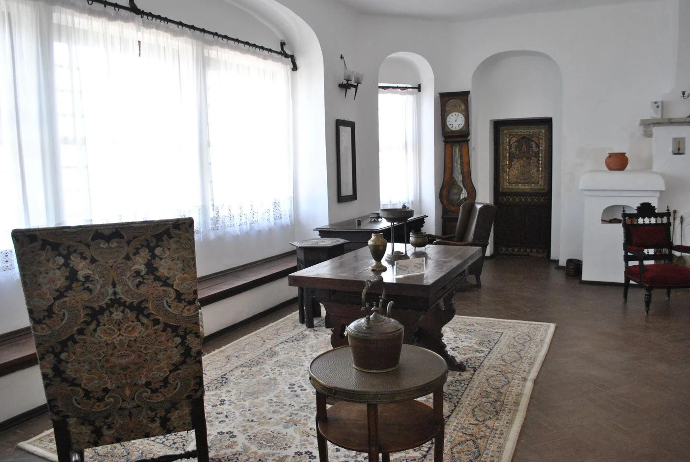 Elegant vintage living room featuring classic wooden furniture and a grandfather clock.