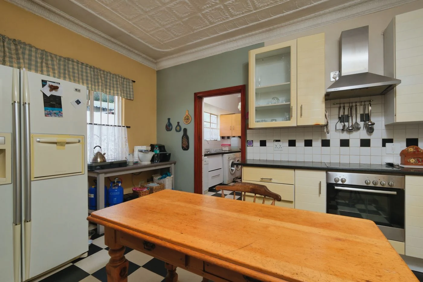 A charming vintage kitchen featuring a rustic wooden table and retro appliances.
