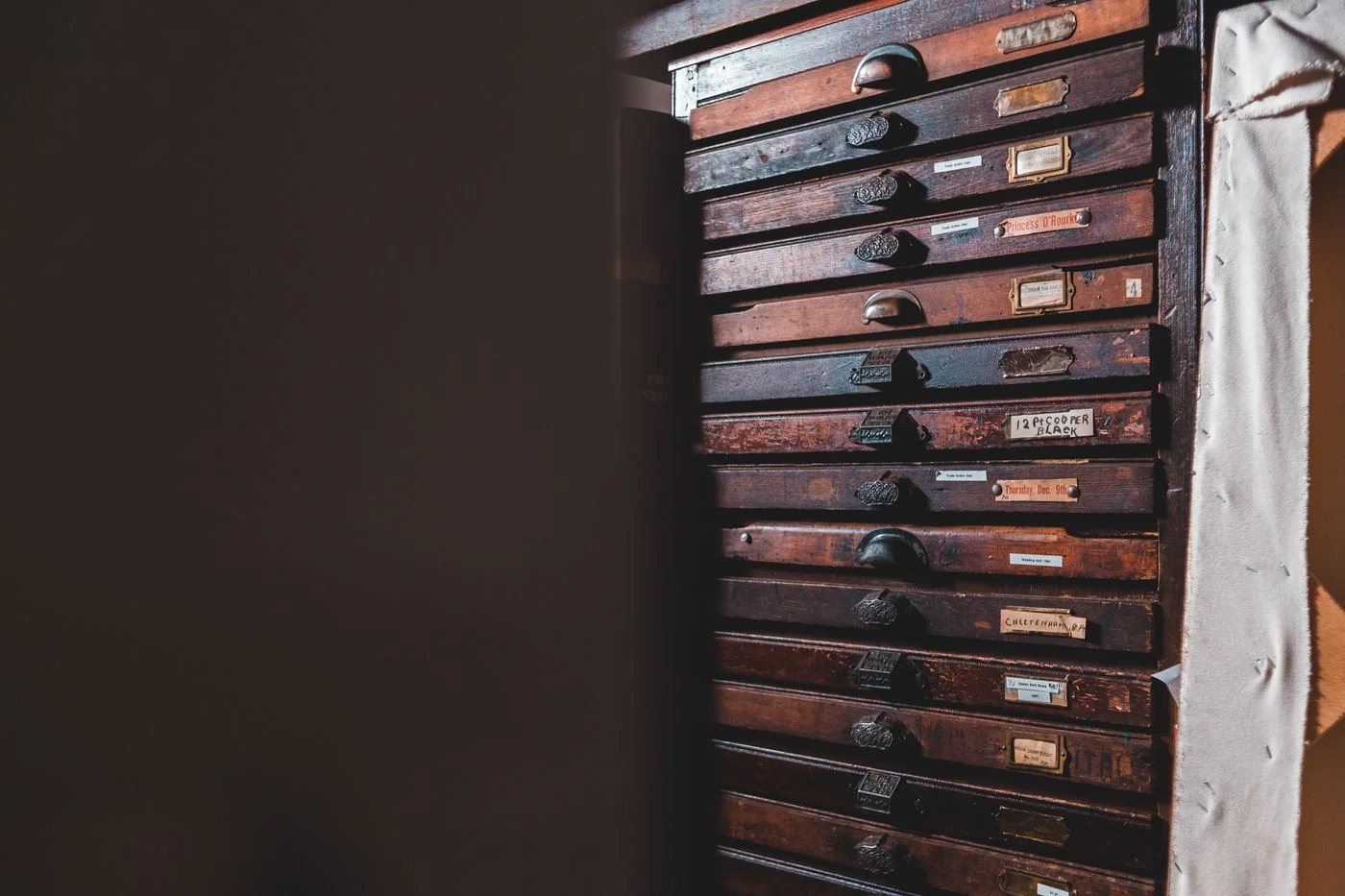 Aged wooden drawer cabinet with labels in a cozy indoor setting, perfect for storage.