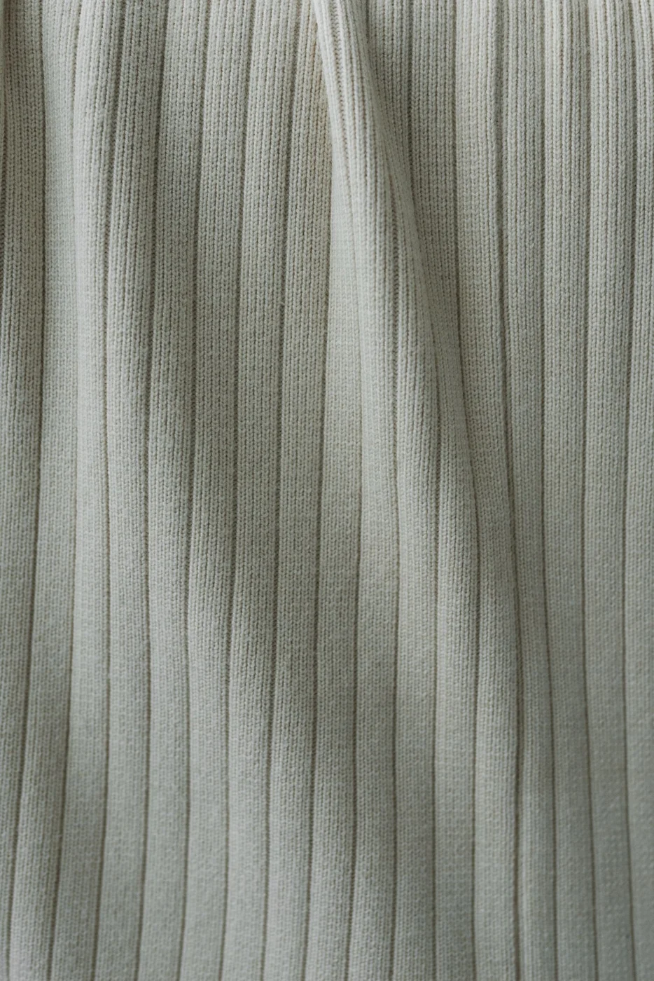 A close view of neutral woven fabric with fine gray stripes.