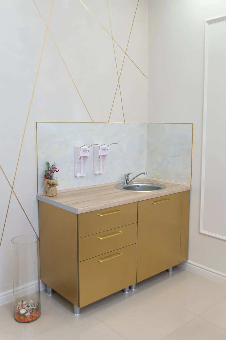 Contemporary gold vanity unit with sink in a minimalist bathroom design.