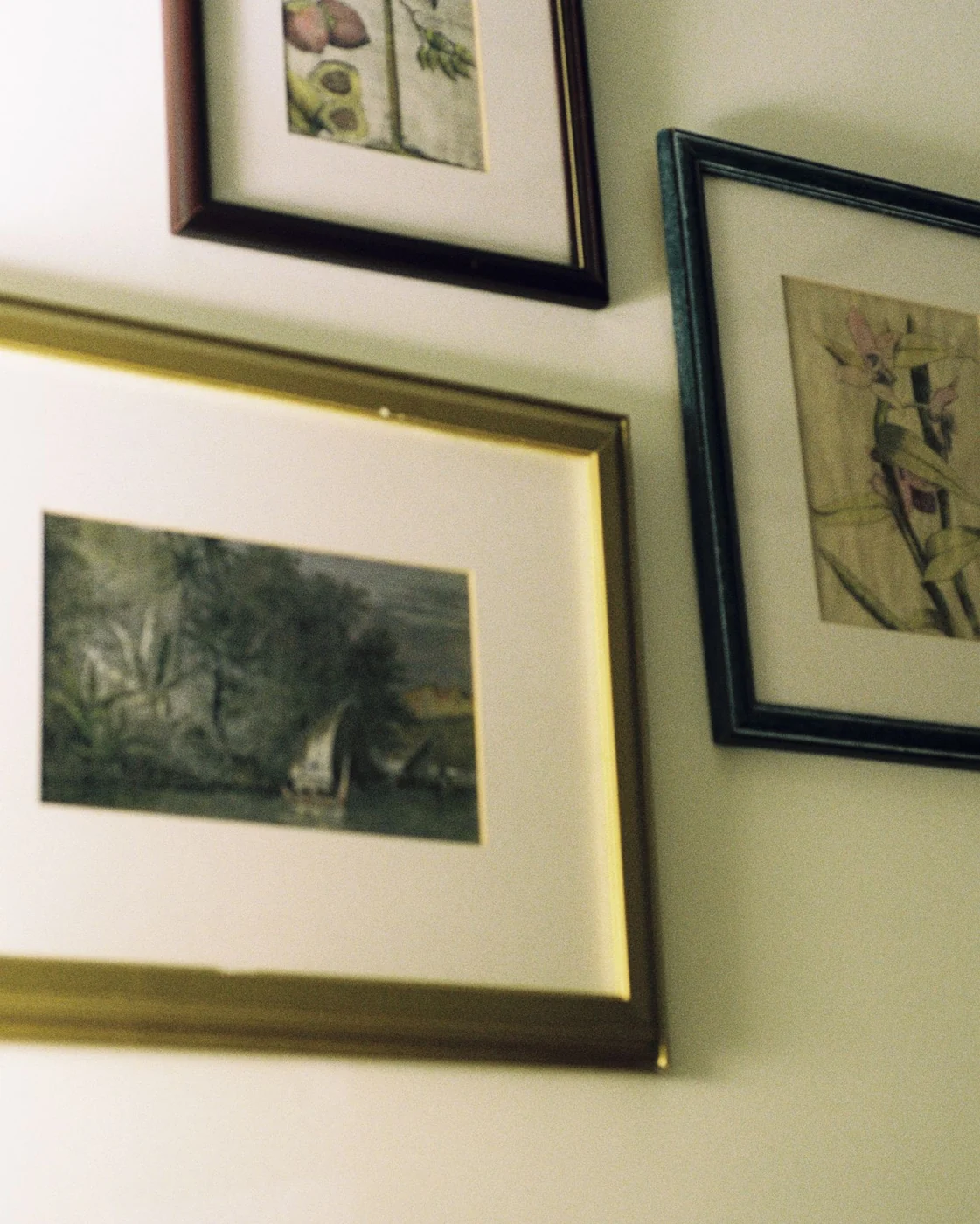 Collection of framed artwork displayed on a wall, showcasing elegant interior decor.