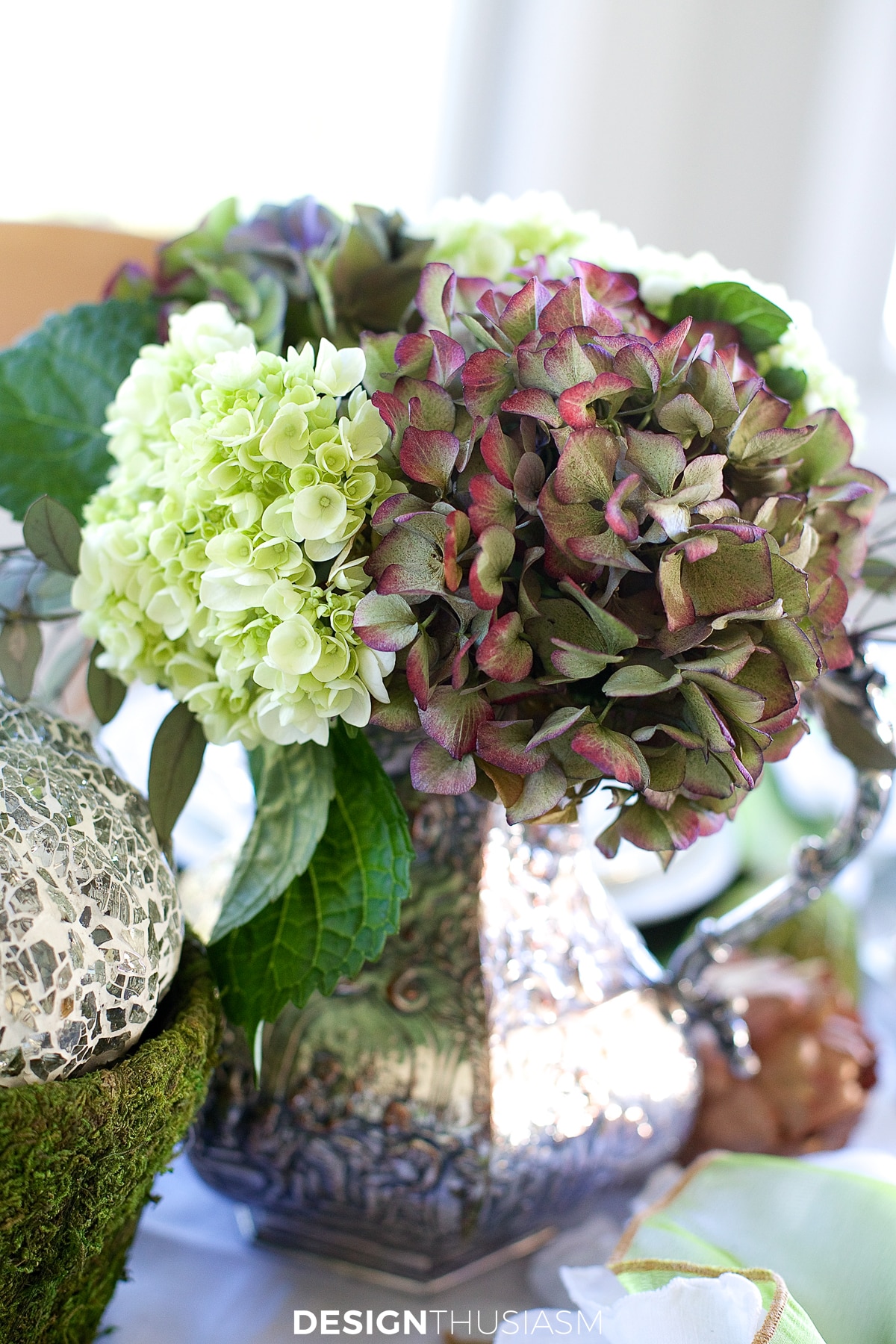 hydrangeas in vintage silver pitcher on casual formal mix table