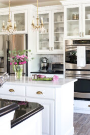 white kitchen with painted glass front cabinets