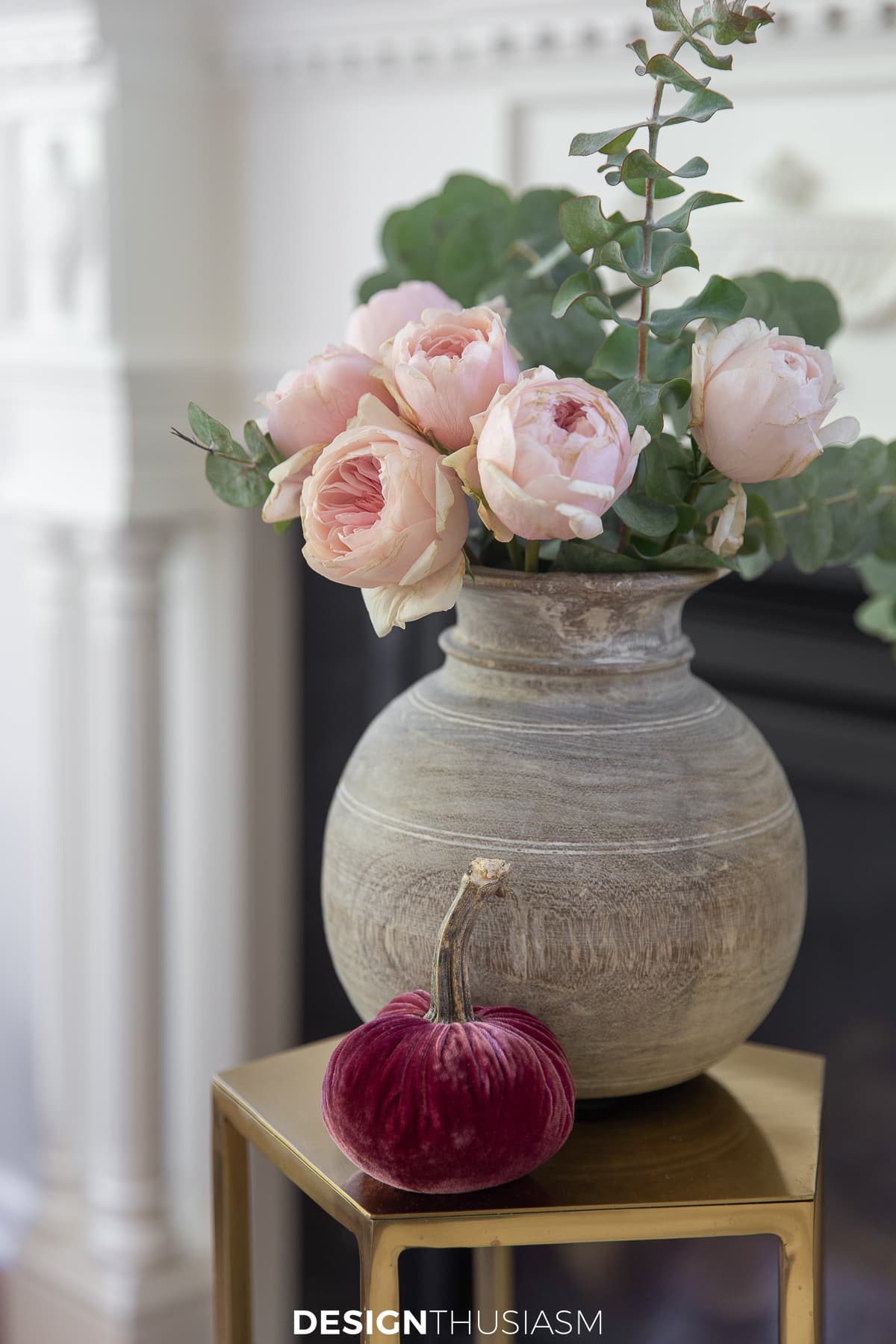 roses and eucalyptus in wood vase with velvet pumpkin
