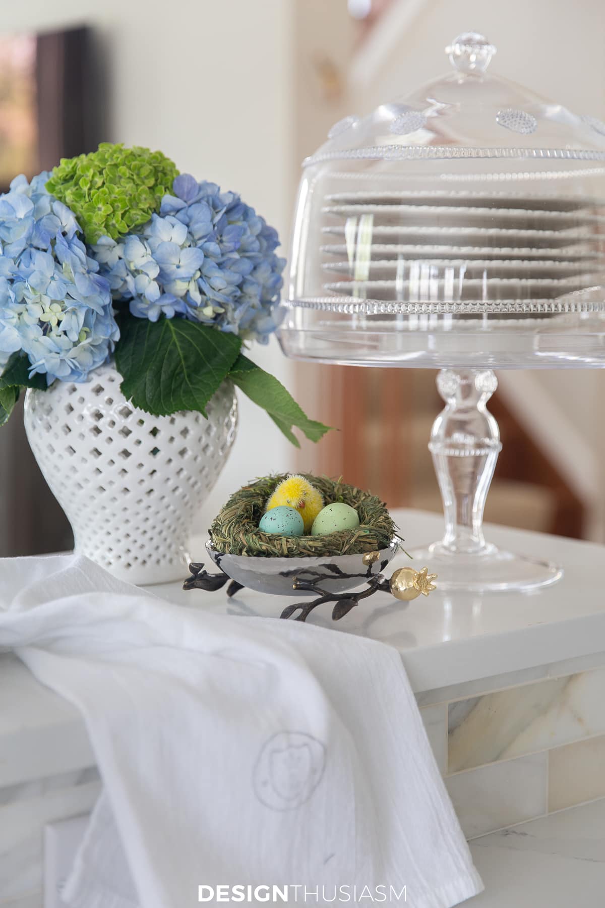 nest with chick and eggs on the counter with hydrangeas