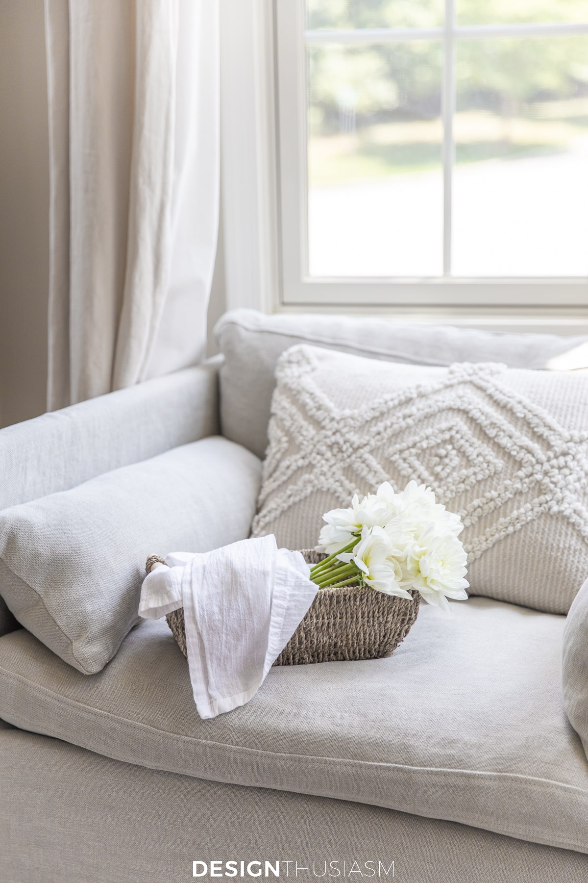 linen club chair with pillow and basket of flowers