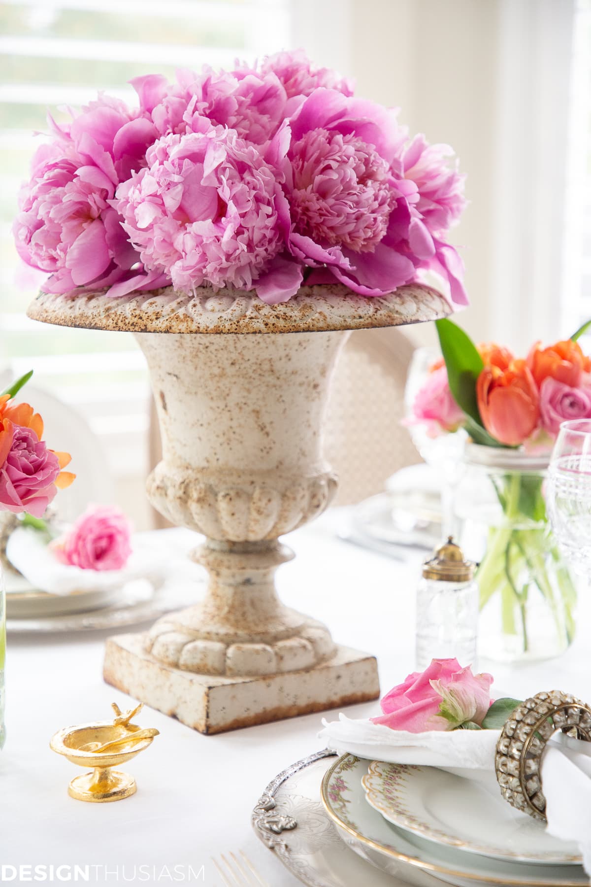white dining table setting with a peony centerpiece