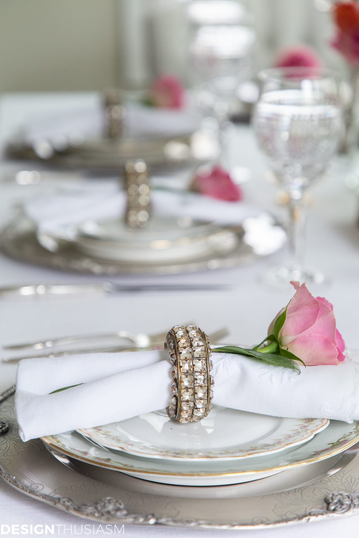 white dining table setting with rose napkin rings