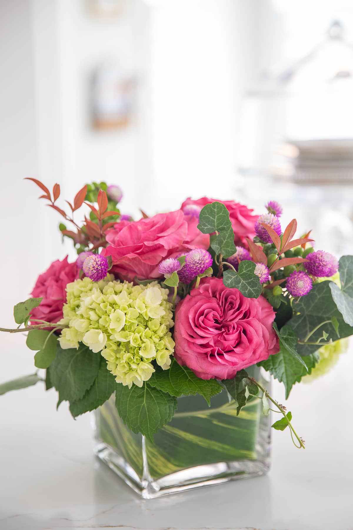 small flower arrangement wrapped with leaves in vase