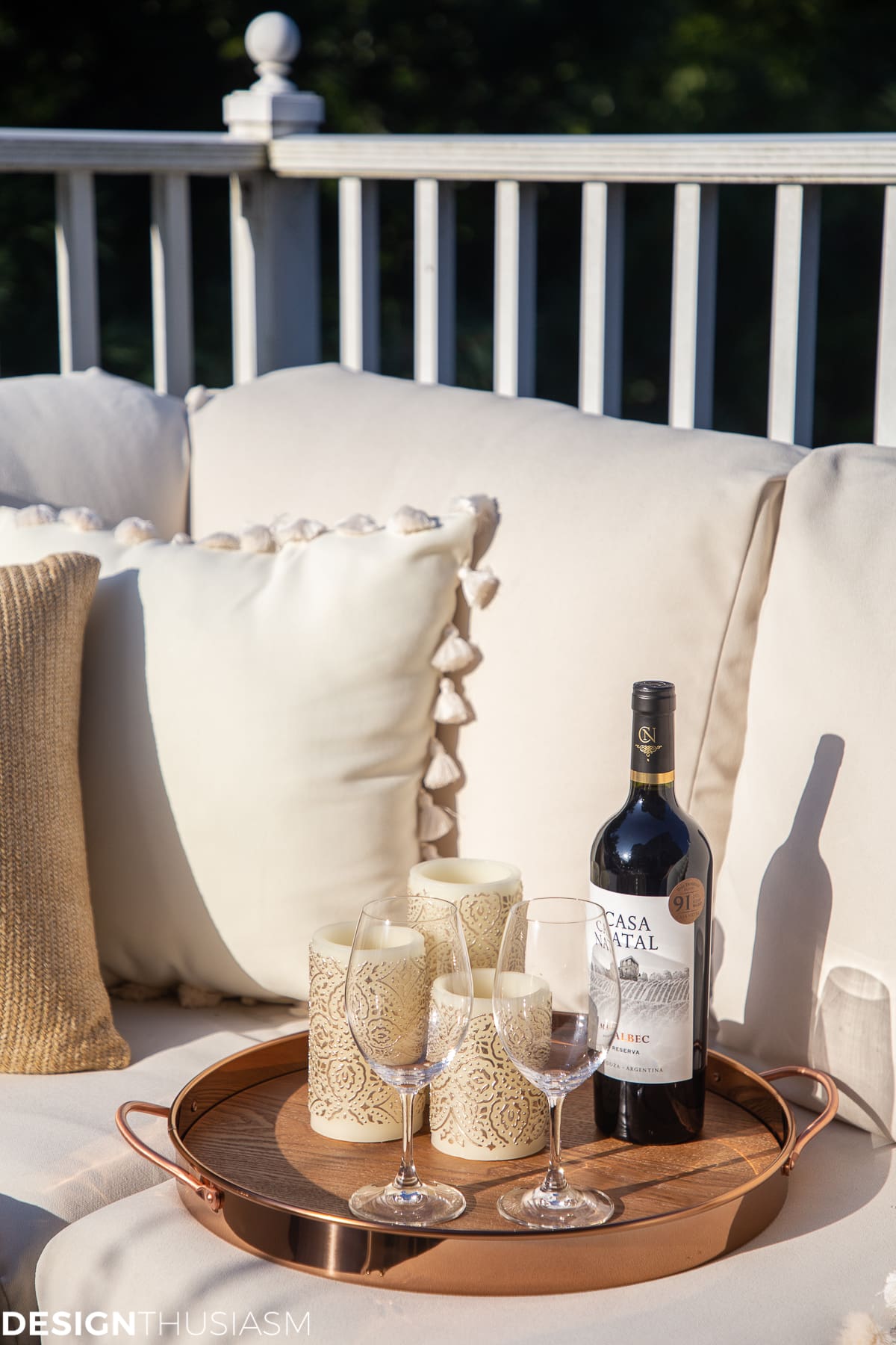 copper tray, pillar candles and wine glasses on the fall patio