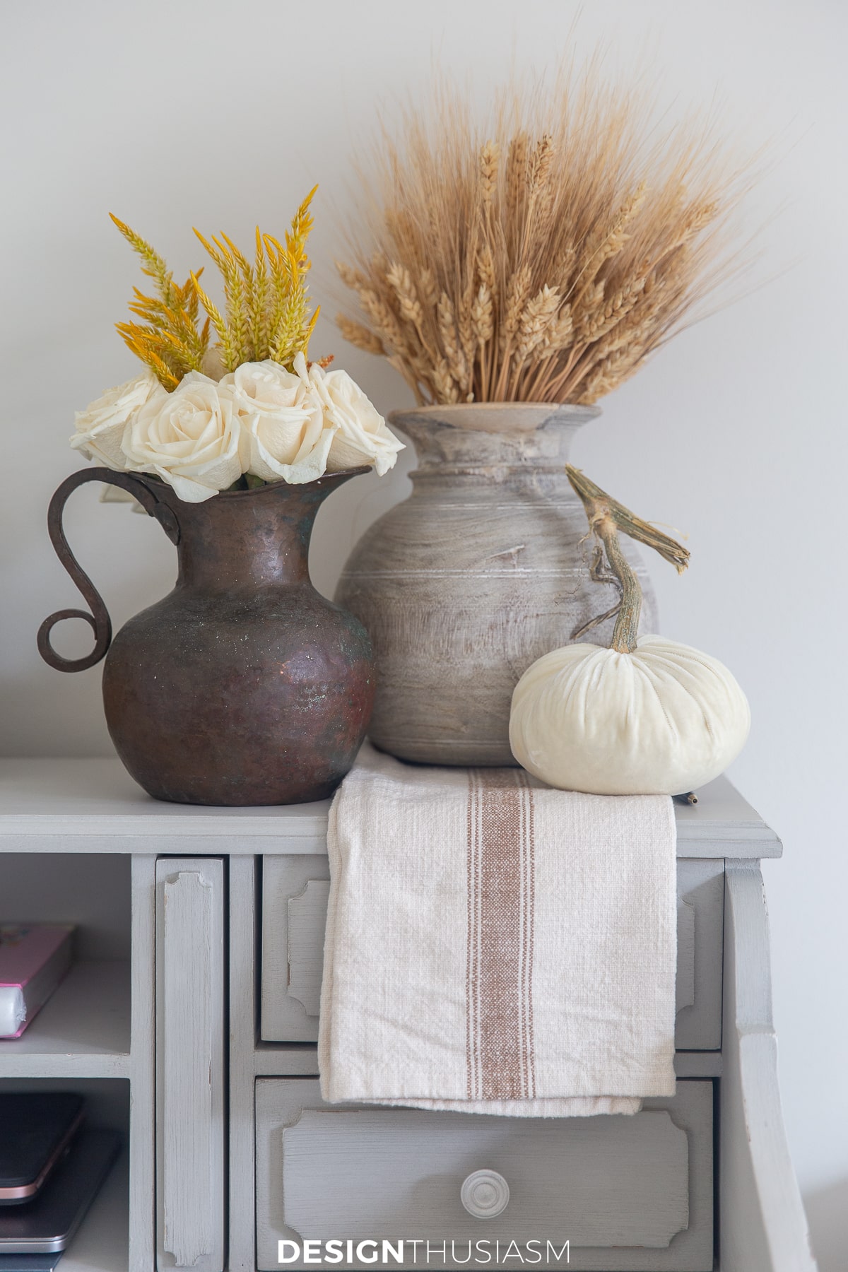 neutral fall decor wheat stacks in vintage wood vase, white pumpkin and cream roses in iron jug