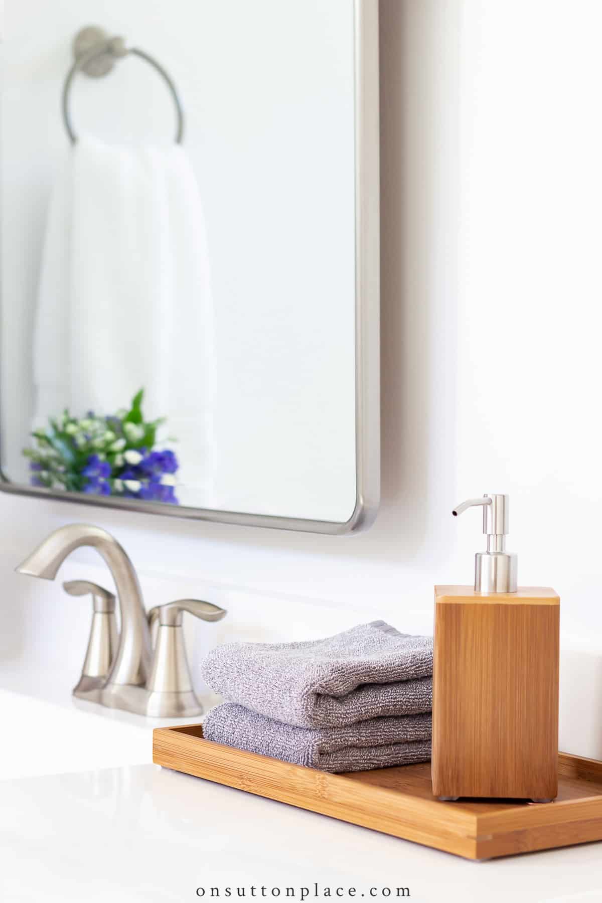 teak tray and soap dispenser on white vanity