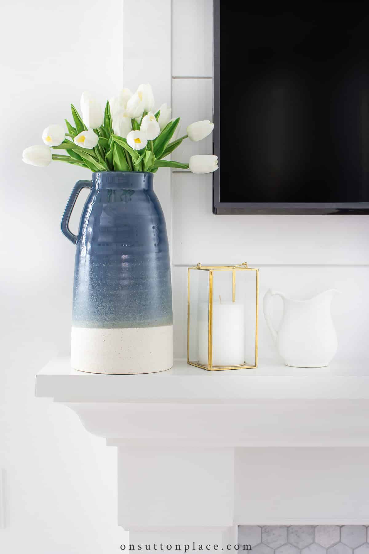 faux flowers in urn on fireplace mantel