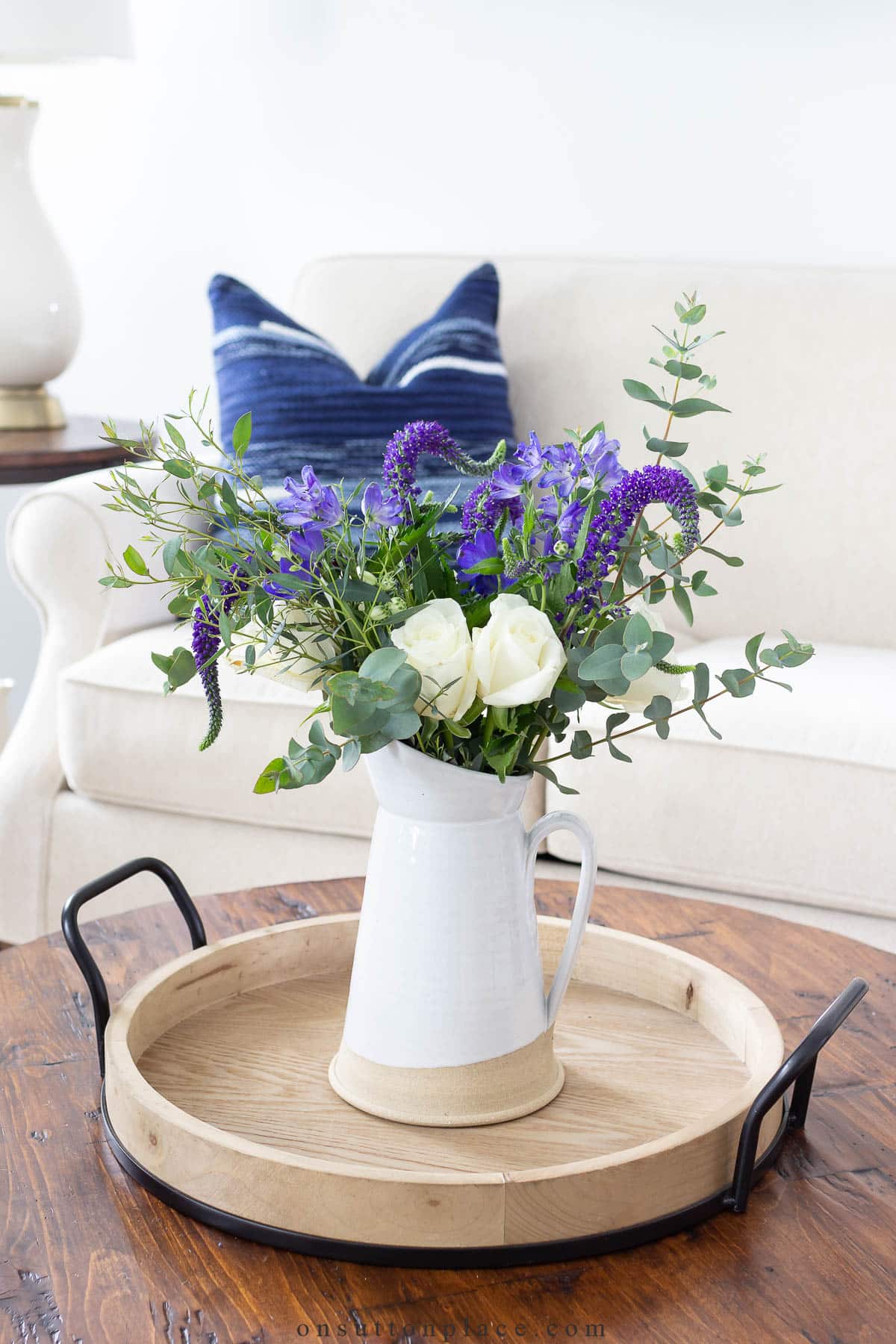 pitcher of flowers round tray round coffee table