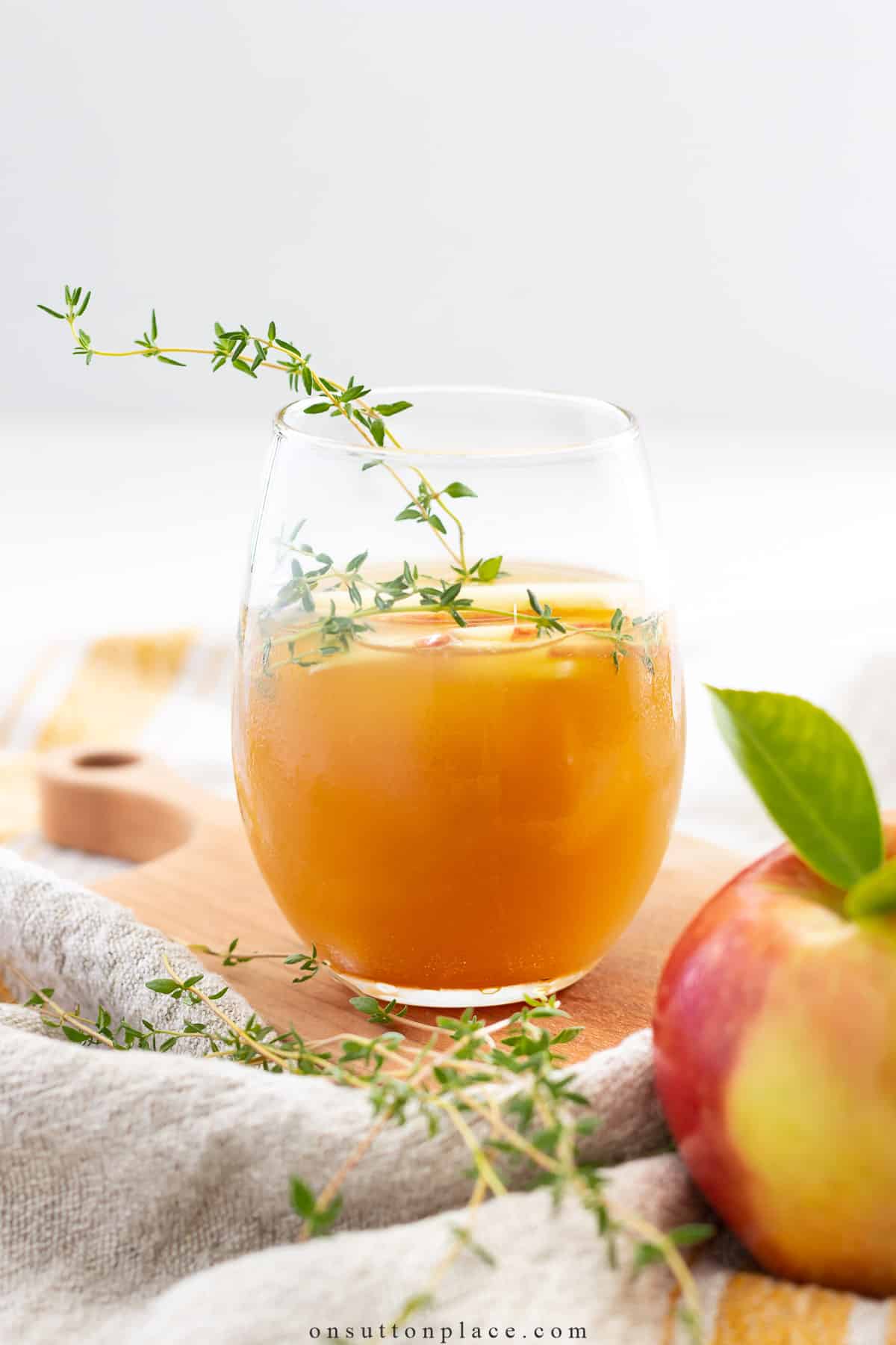 apple and ginger beer mocktail in clear glass with thyme
