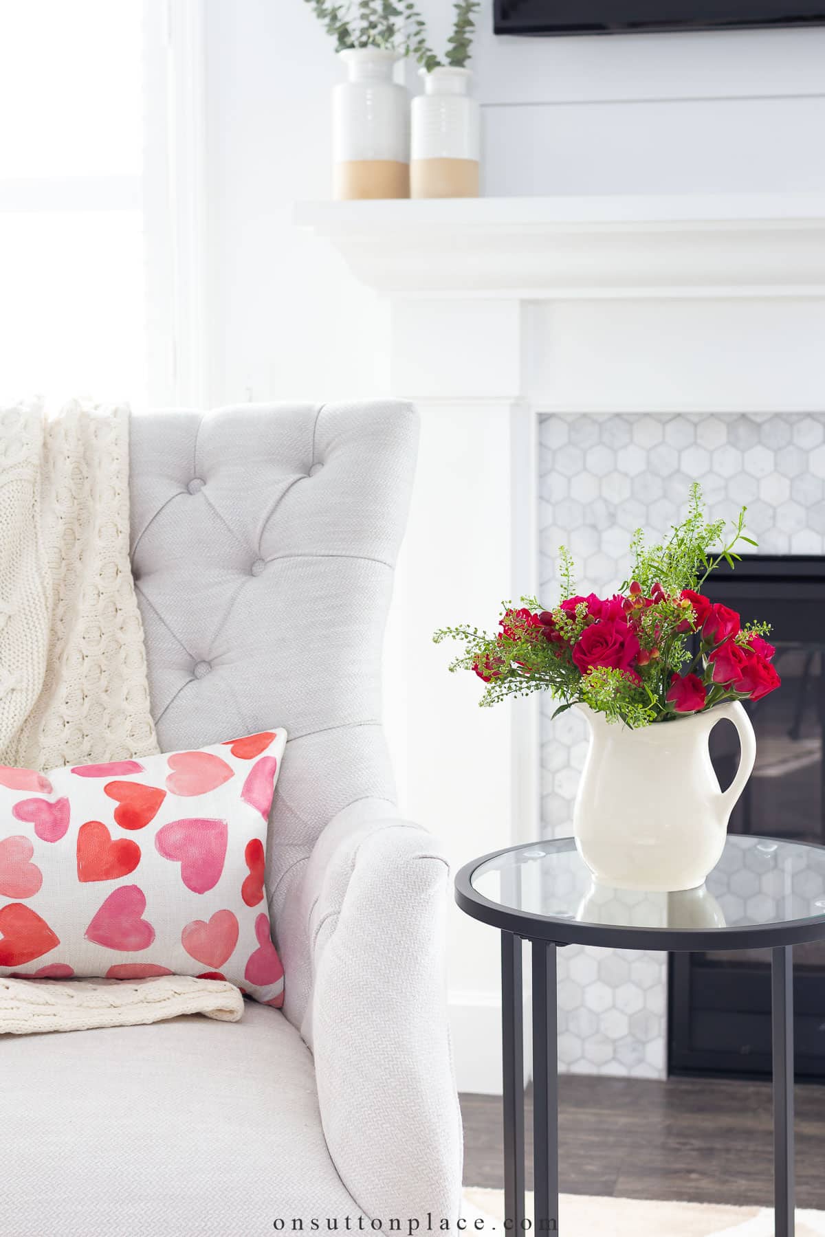 watercolor heart pillow on tufted chair