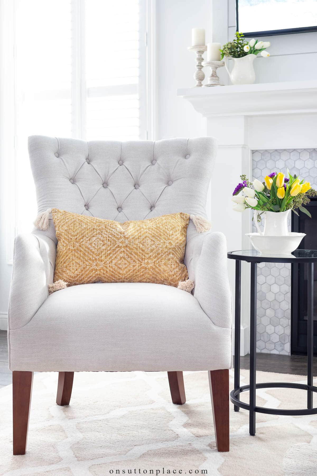 spring ideas add yellow pillow on neutral tufted chair in living room