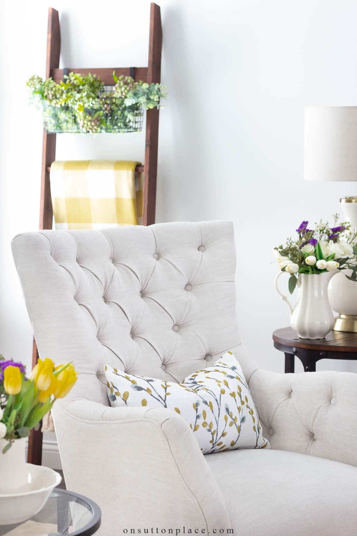 neutral tufted chair with yellow floral spring pillow