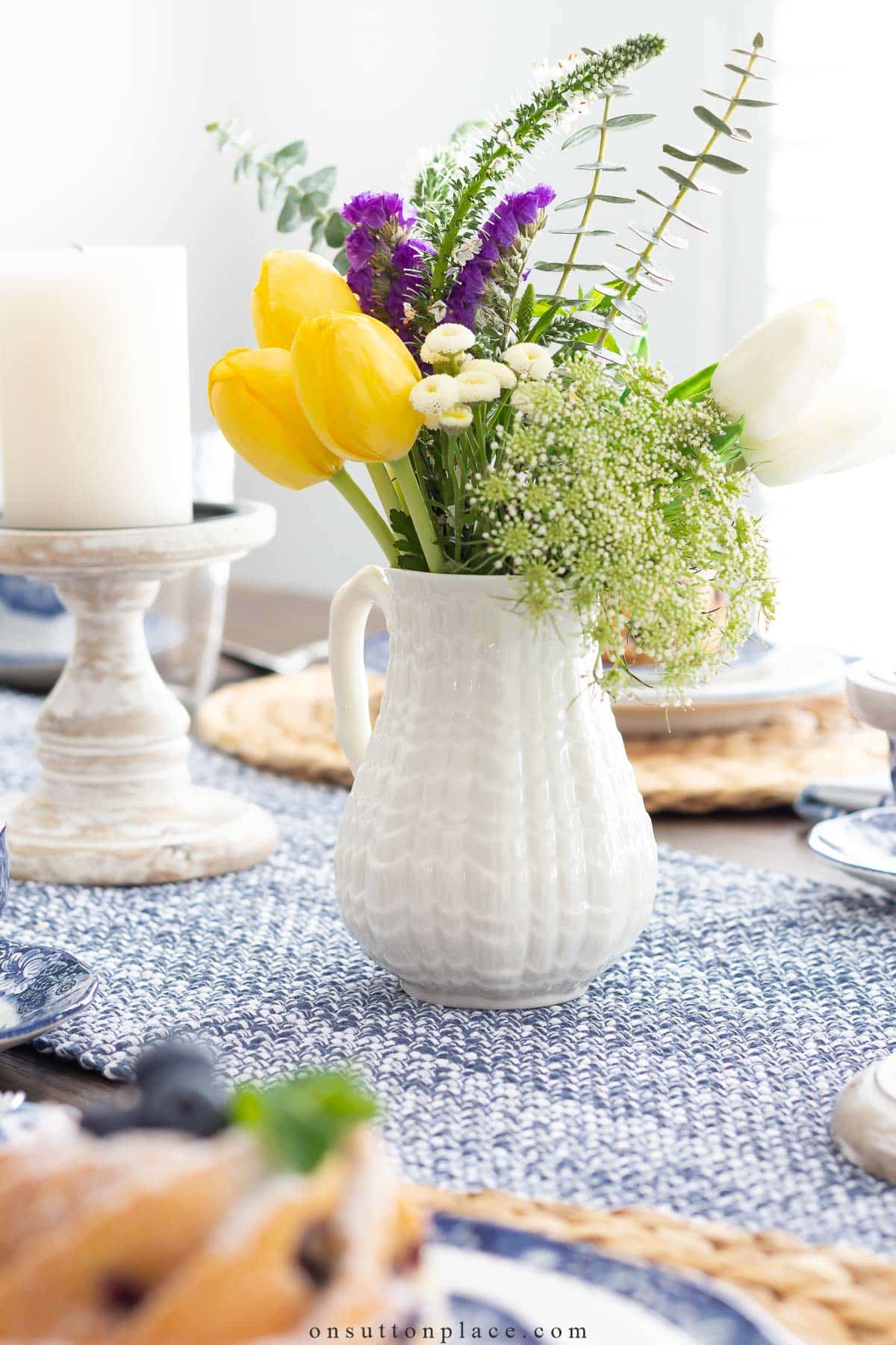 pitcher of spring flowers on blue table runner