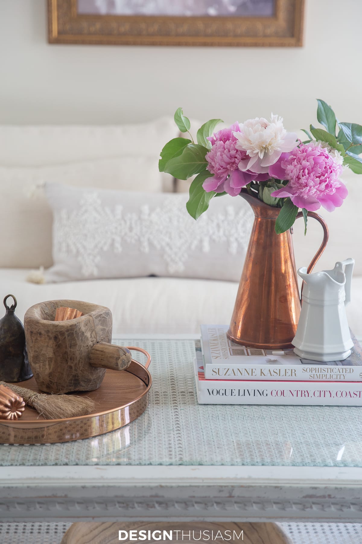 copper pitcher with peonies on a coffee table