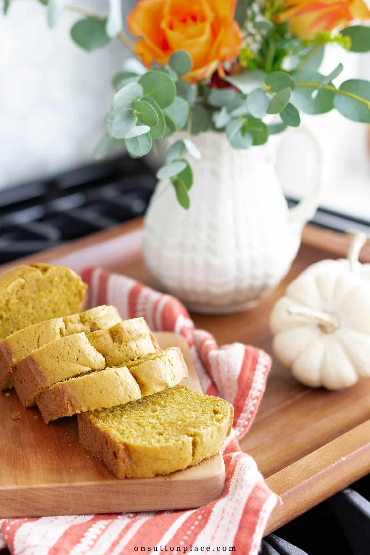 sliced pumpkin bread on wood board on stovetop www