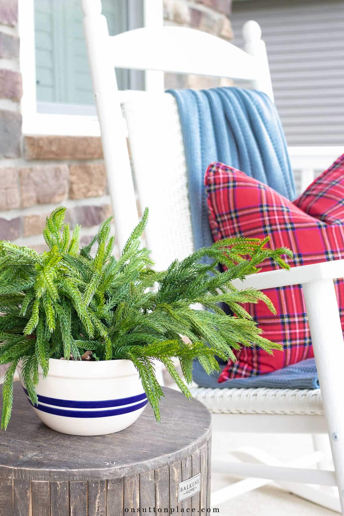 bowl of Norfolk pine on front porch beside white rocker