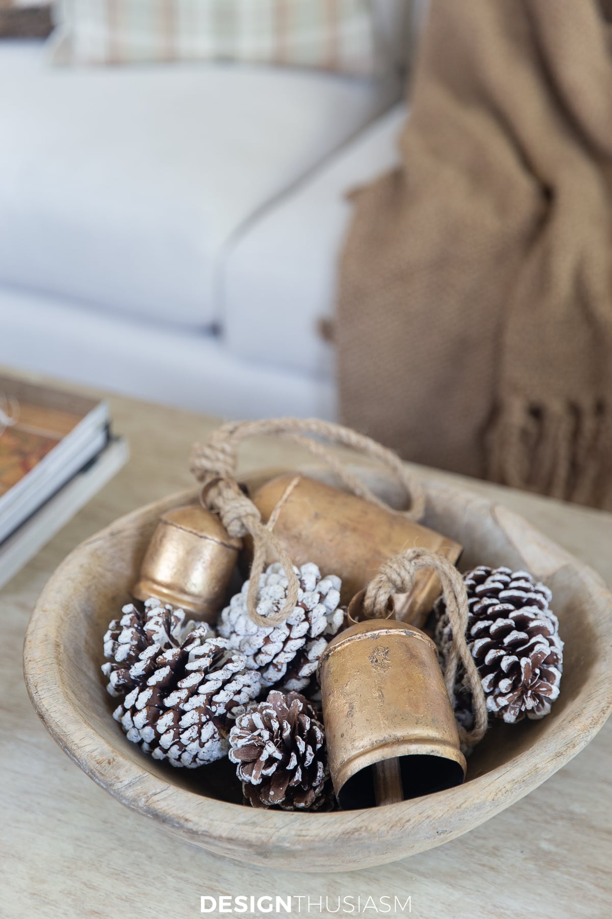 wood bowl with pine cones and cow bells