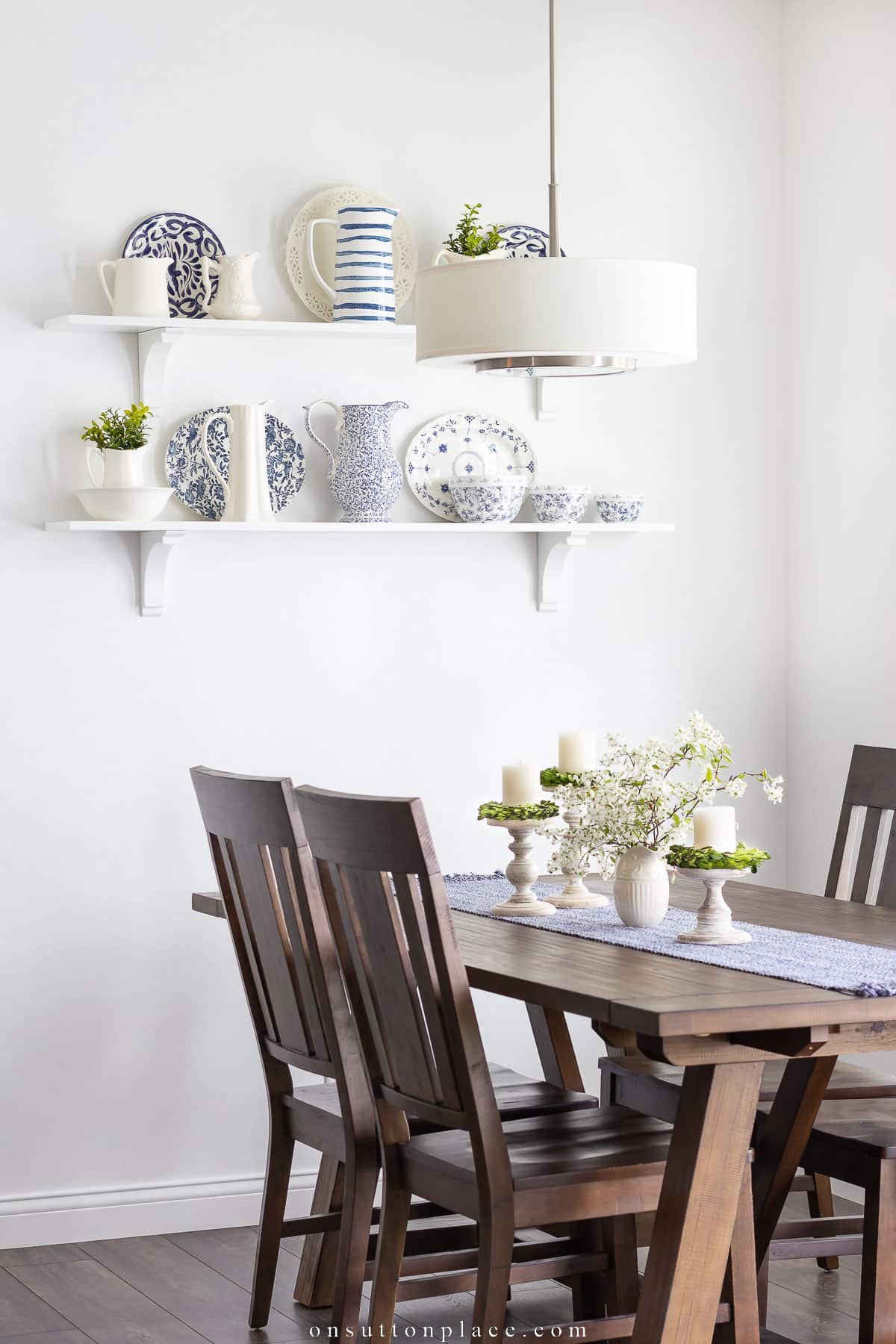 collection of pitchers and plates on wall shelves in dining nook 2023