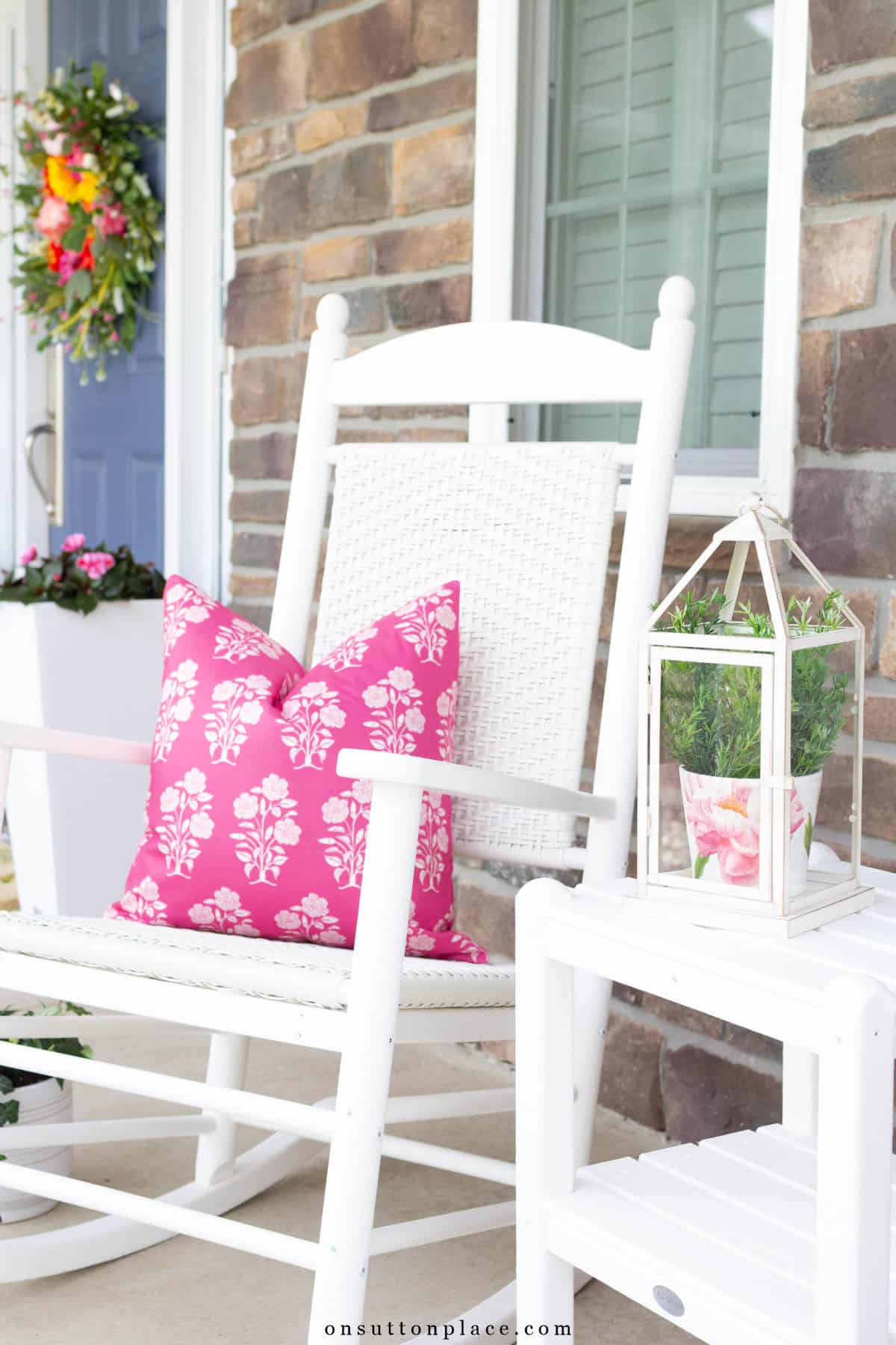 white rocker on front porch with pink block print pillow