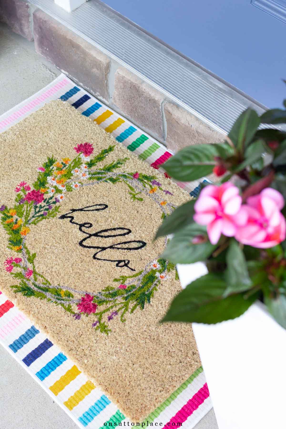 coir doormat layered over colorful striped rug